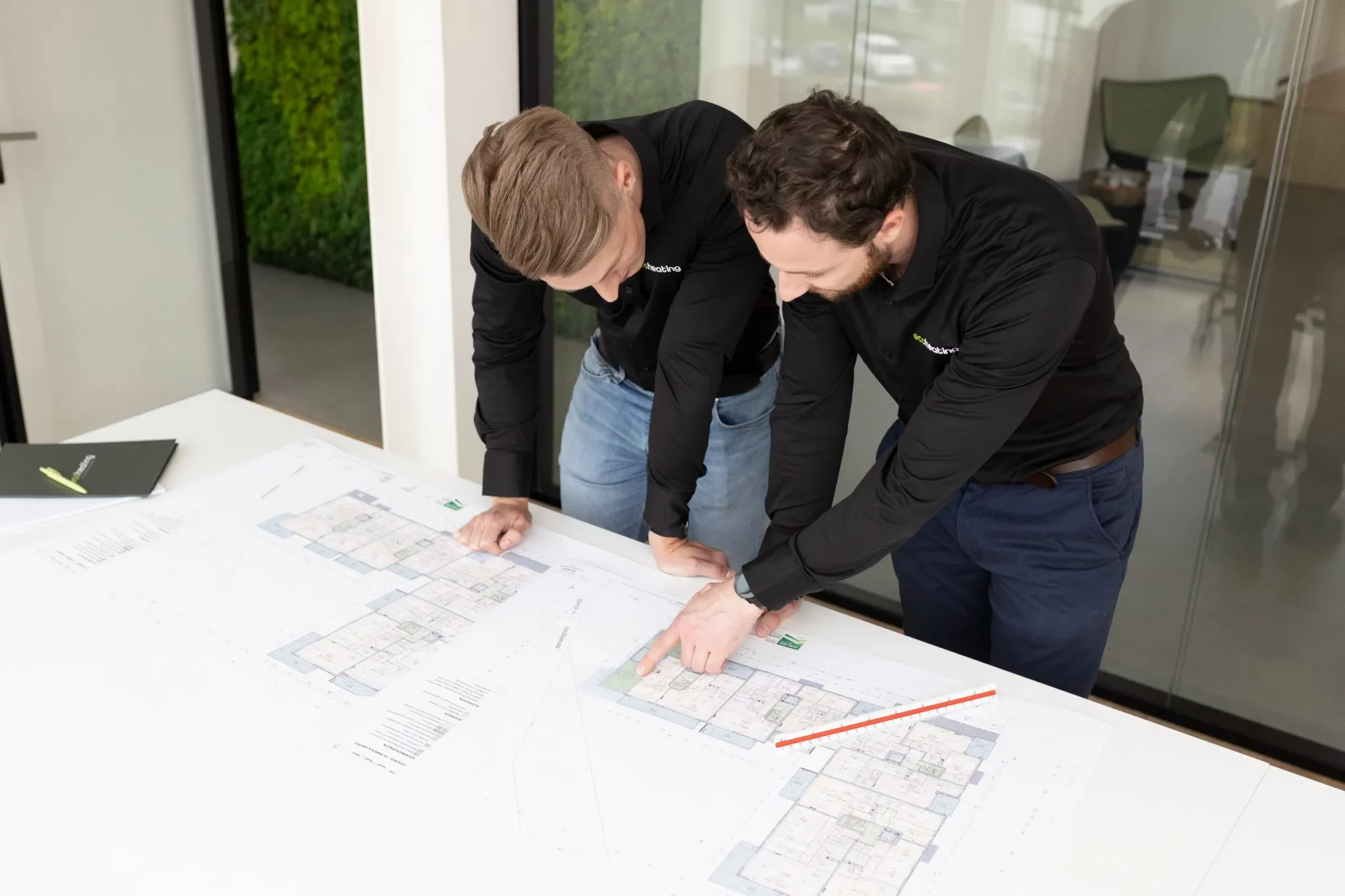 Technisch tekenaars van Eco Heating Group overlopen samen de plannen van een appartementsproject